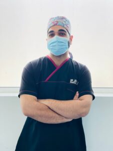 a man wearing a surgical mask and scrubs